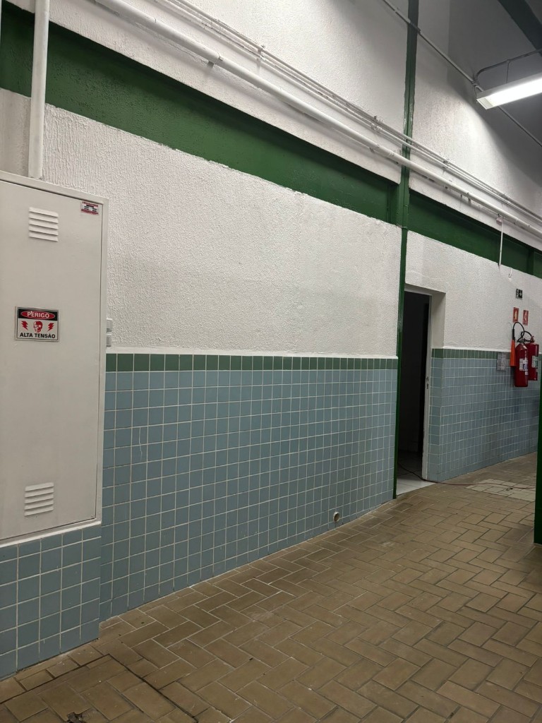 Área comum finalizada com parede branca e azulejos limpos