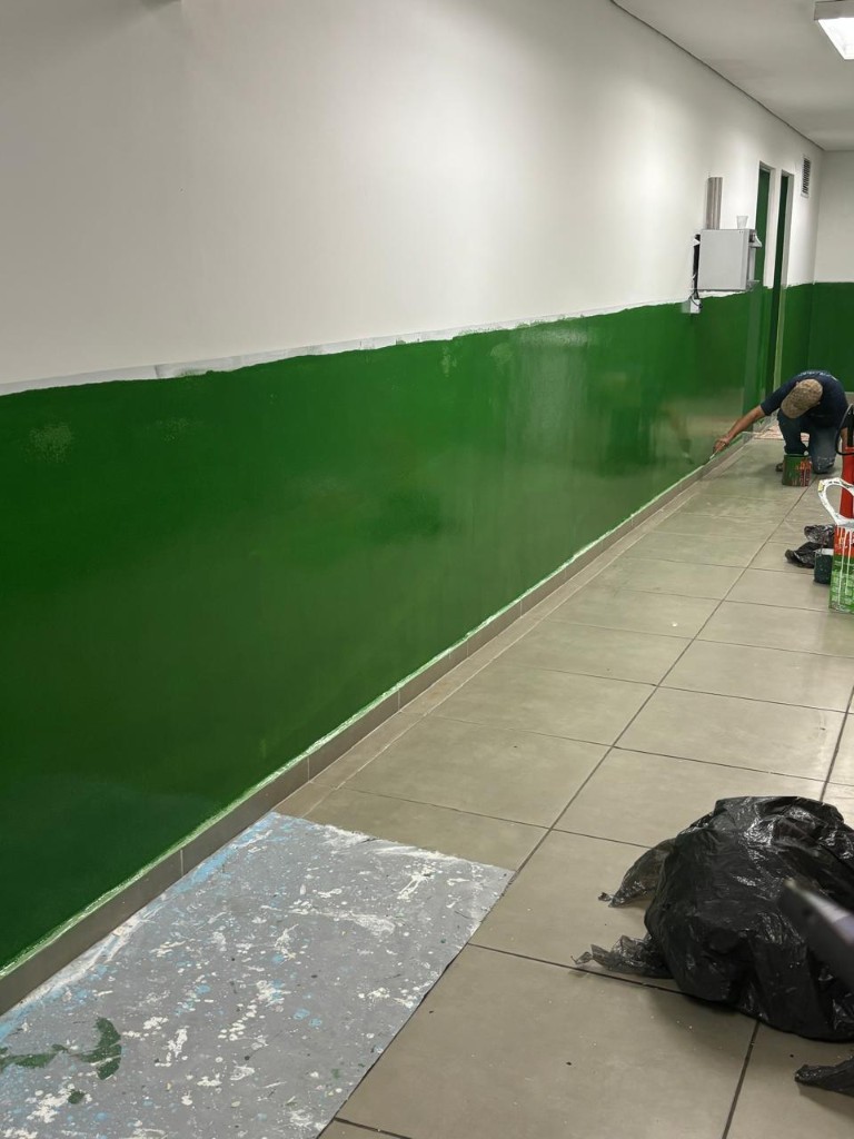 Corredor com parede verde renovada durante a pintura