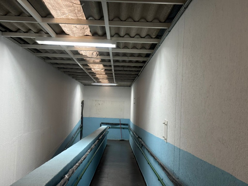 Corredor interno com pintura azul e branca em fase de acabamento