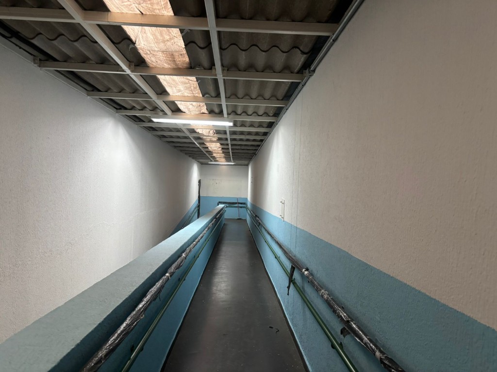Corredor em processo de pintura com proteções nas laterais